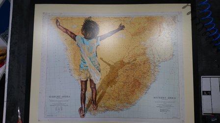 Stunning map of South Africa with a drawing of a child of the foreground | off white photo mount | thin black picture frame.